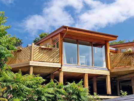 A modern building with a balcony and glass doors at Piran Spa Lodge Pet in Perranporth