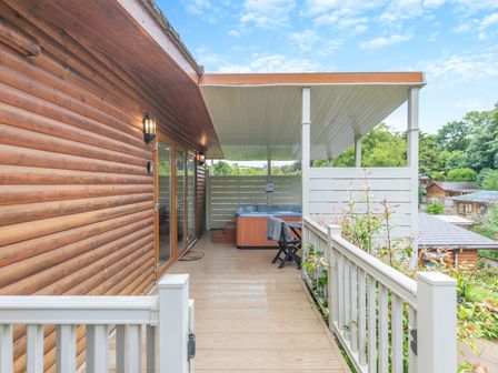 An outdoor deck with a hot tub at Chapel Rock Spa Pet in Perranporth