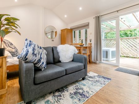 A living room with a sofa and dining table at Droskyn Spa Pet Perranporth