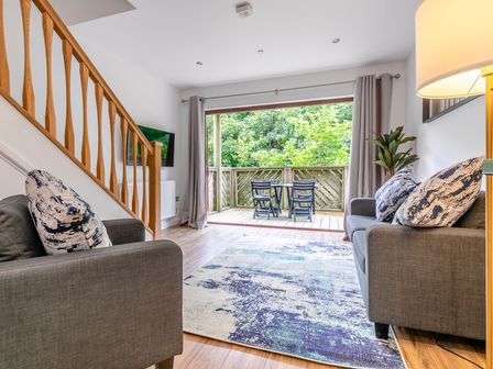 A living room with a sofa and television at Treehouse Spa in Perranporth