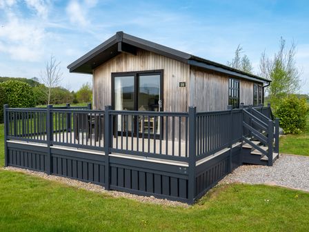 A cabin with a deck and railing in Stokesley (Pet) Great Ayton