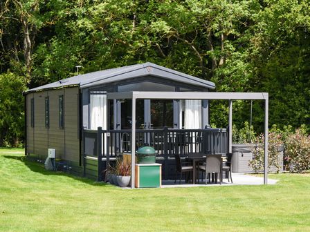 A mobile home with a deck and outdoor furniture at The Woods in Great Ayton