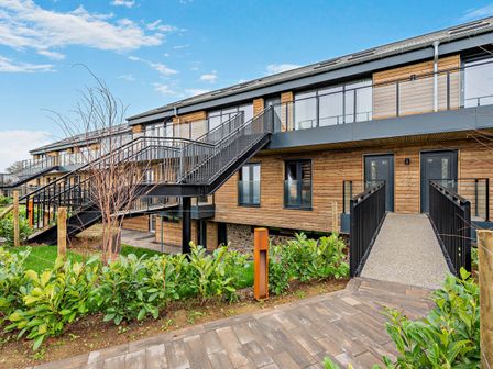 An outdoor view of a wooden building with stairs and pathway at Arvor Duplex 2.0 Marhamchurch