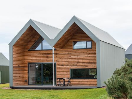 A modern house with a wooden exterior and large windows at The Laidlaw Spa in North Berwick