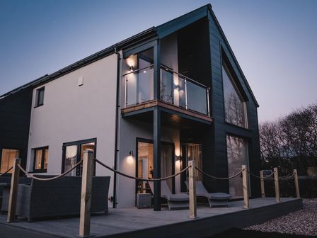 A house with a balcony and outdoor furniture at The Glasshouse in Bude