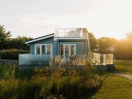 A house with a balcony and glass railing at Sennen 3 Spa Roof Terrace in Bude