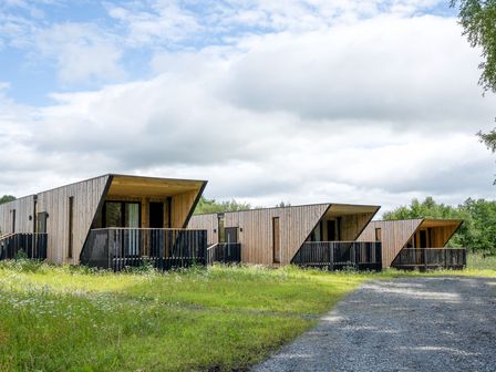 Wooden lodges with balconies in a grassy area at Orka Duo 2.0 (Pet) Dumfries
