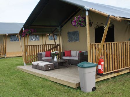 A patio with outdoor seating and a coffee table at Standard Safari Tent in Fair Oak