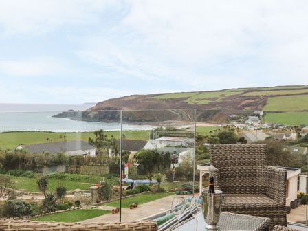 An outdoor seating area overlooking the ocean and hills at Praa Waves in Penzance