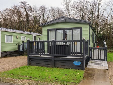 A caravan with a deck at Borewicks Lakes
