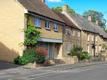 A house with a flower bed and pathway at Greenham Rise in Norton-Sub-Hamdon