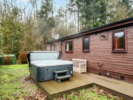 An outdoor area with a hot tub and wooden deck at Cabin 1 Moffat Manor in Beaufort
