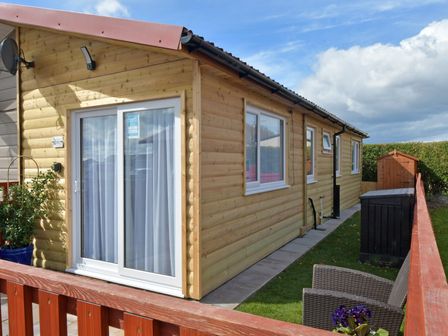 A cabin with patio furniture and a garden shed at 228b Eighth Avenue in Bridlington