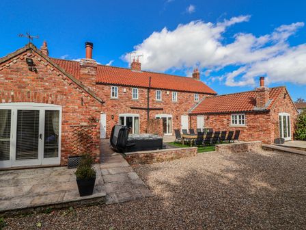 An outdoor area with a table and chairs at Champagne Cottage Weaverthorpe