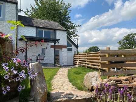 An outdoor area with a stone path and flowers at The Haven in Penrith