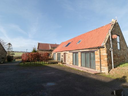 A stone building with a red roof and windows at Millstone Cottage Sneaton Thorpe near Whitby