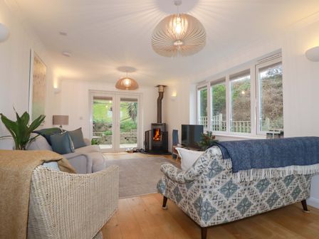 A living room with a fireplace and television at Poldreth in Truro