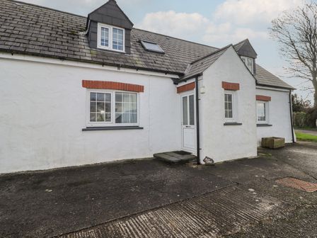 A house with a white exterior and windows at Rhosgranog Cottage Llandeloy near Solva