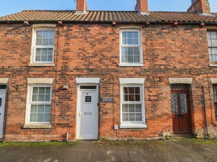 An outdoor view of a brick house with a door and windows at No.4 Main Street in Hull