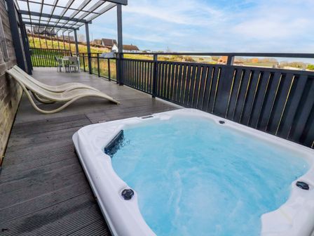 An outdoor area with a hot tub and seating at 114 - The Residance in Redruth