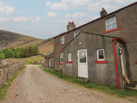 A house exterior near a dirt path at Easthwaite Cottage in Nether Wasdale near Wastwater