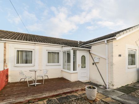 An outdoor space with a table and chairs at Primrose Cottage in Chathill