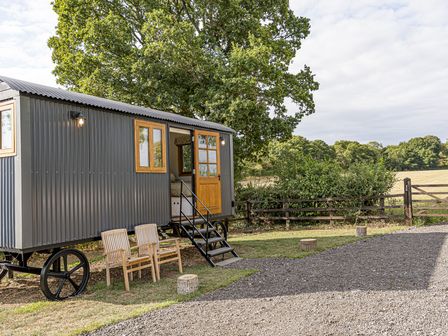 A trailer with wooden chairs outside at No 2 The Parkland Upton Warren