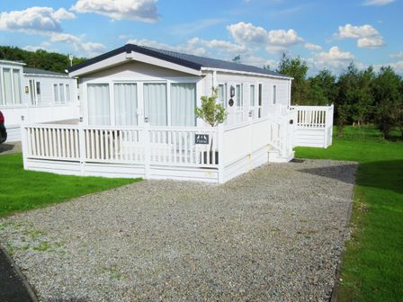 A manufactured home with a porch and gravel driveway at No. 4 Fistral in Newquay