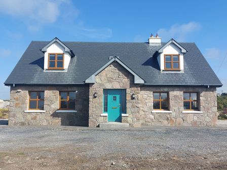 A house with stone facade and a teal door at Tigh Marie