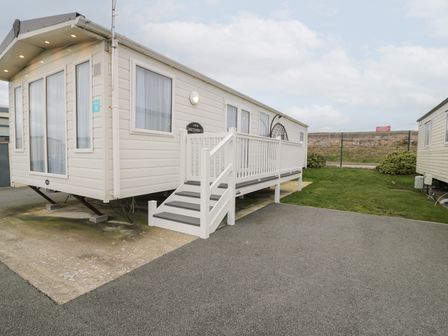 A caravan with steps on grass at 11, Beachfields