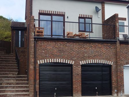 A house with a balcony and garages at Upper Longlands Dawlish