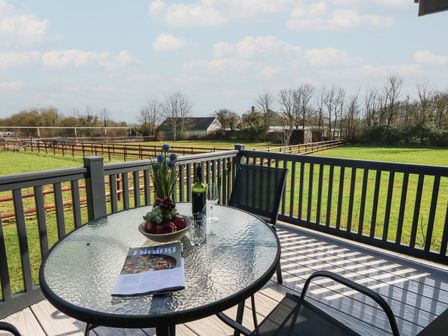 A table with a bottle and glass on a patio at Grass Roots in