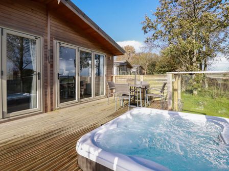 An outdoor area with a hot tub and seating at 20 Meadow Retreat in Dobwalls