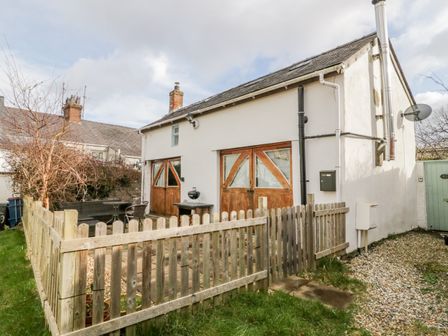 A house with wooden doors and a fenced area at Studio Bach in Beaumaris