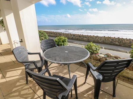 A table and chairs facing the sea at Rock House in Narberth