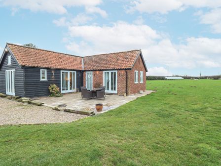 An outdoor area with a barn and seating at Ivy Barn in Norwich