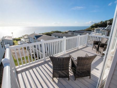 An outdoor area with chairs overlooking the sea at Devon Cliffs Holiday Park - Holiday Accommodation 14142, Exmouth