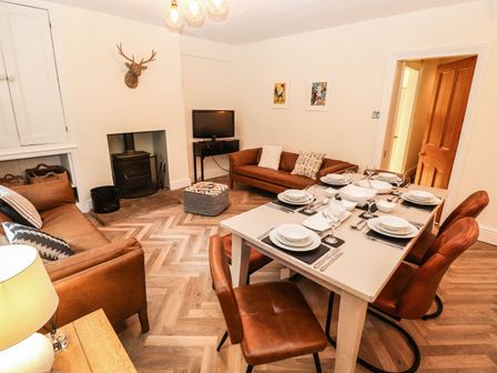 A dining room with a table set for meals at Waterhead Cottage in Ambleside