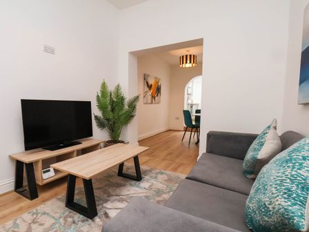 A living room with a television and coffee table at Holmwood