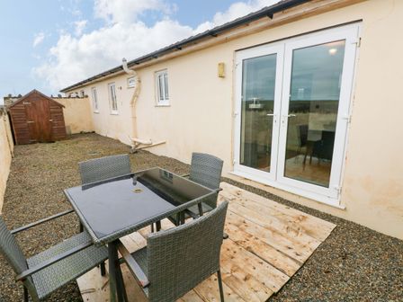 An outdoor area with a table and chairs at Red Kite Cottage Haverfordwest