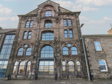 A building with multiple windows and a central entrance at Mill Wharf in Berwick-upon-Tweed
