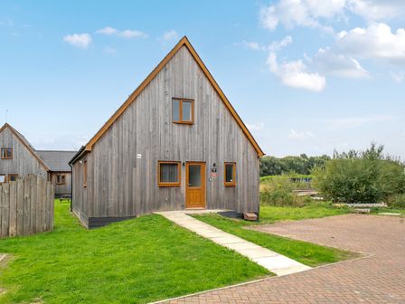 A house with a wooden exterior and pathway at Lodge 25 - Pumpkin Near Brigg