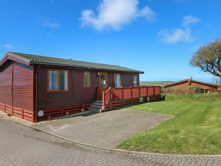 A wooden cabin with a deck and steps at 1 Ocean Terrace Ilfracombe
