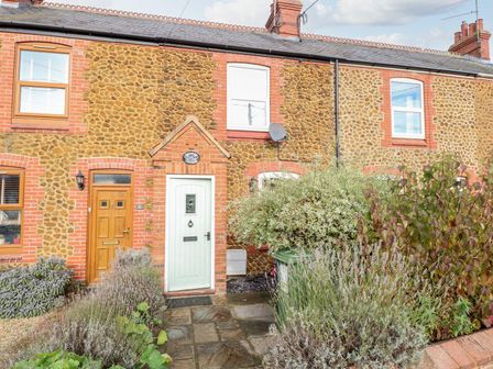 A front view of a cottage with a stone wall and garden at Bay Tree Cottage in King's Lynn