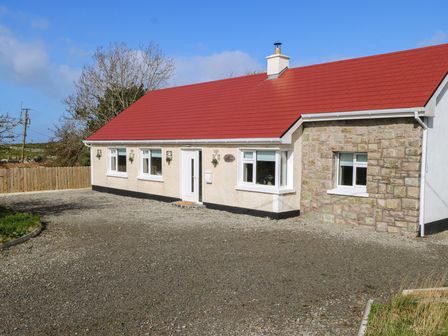 A house with a red roof and gravel driveway at Doire Fhatharta Beag in Carraroe, County Galway