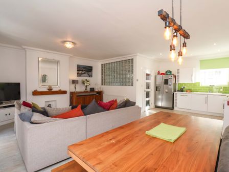 A living room with a sofa and kitchen area at The Four Views in Whitby
