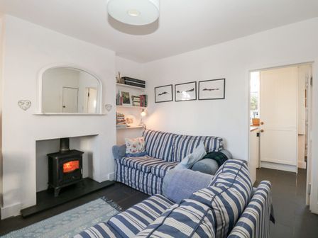 A living room with a sofa and fireplace at Burnside Cottage in Grange-Over-Sands