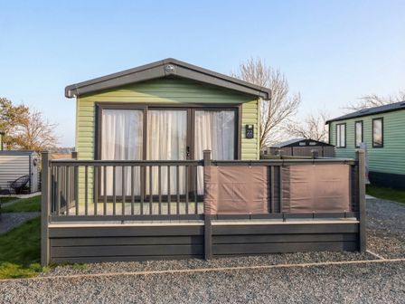 A cabin with a deck and railing at Lodge 22, Moselle in Malton