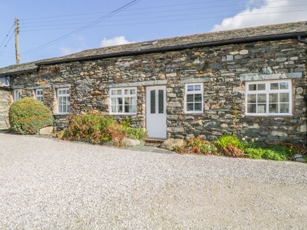 A stone building with windows and a front door at Cottage 2 in Keswick