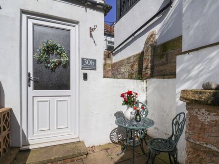 An outdoor seating area with a table and flowers at Marina House in Whitby